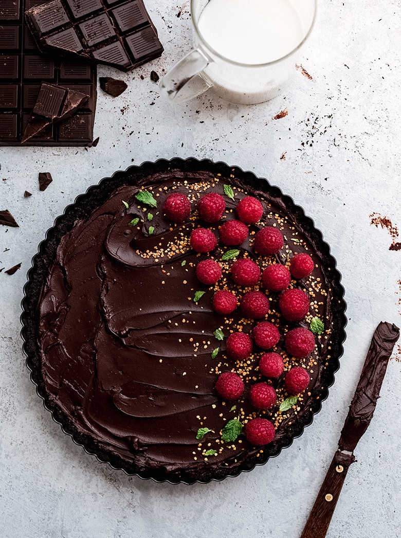 No-Bake Chocolate Tart made with an oreo crust and a dark chocolate ganache filling. Topped with fresh raspberries.