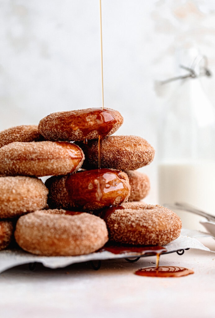 Homemade baked apple cider donuts are the perfect fall treat. Covered in browned butter and cinnamon sugar and topped with warm maple.