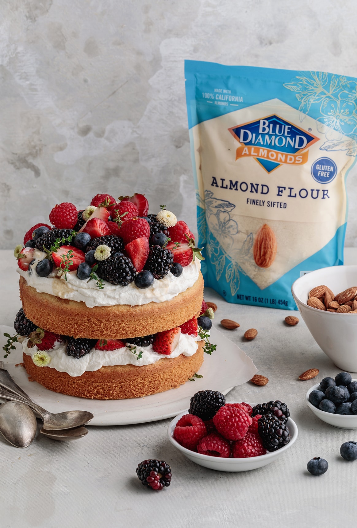 Delicious and easy to make Gluten-free Berries and Almond Cake made with almond flour and topped with maple whipped cream and seasonal berries.