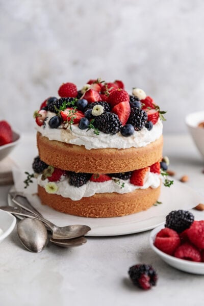 layered almond cake with whipped cream and berries