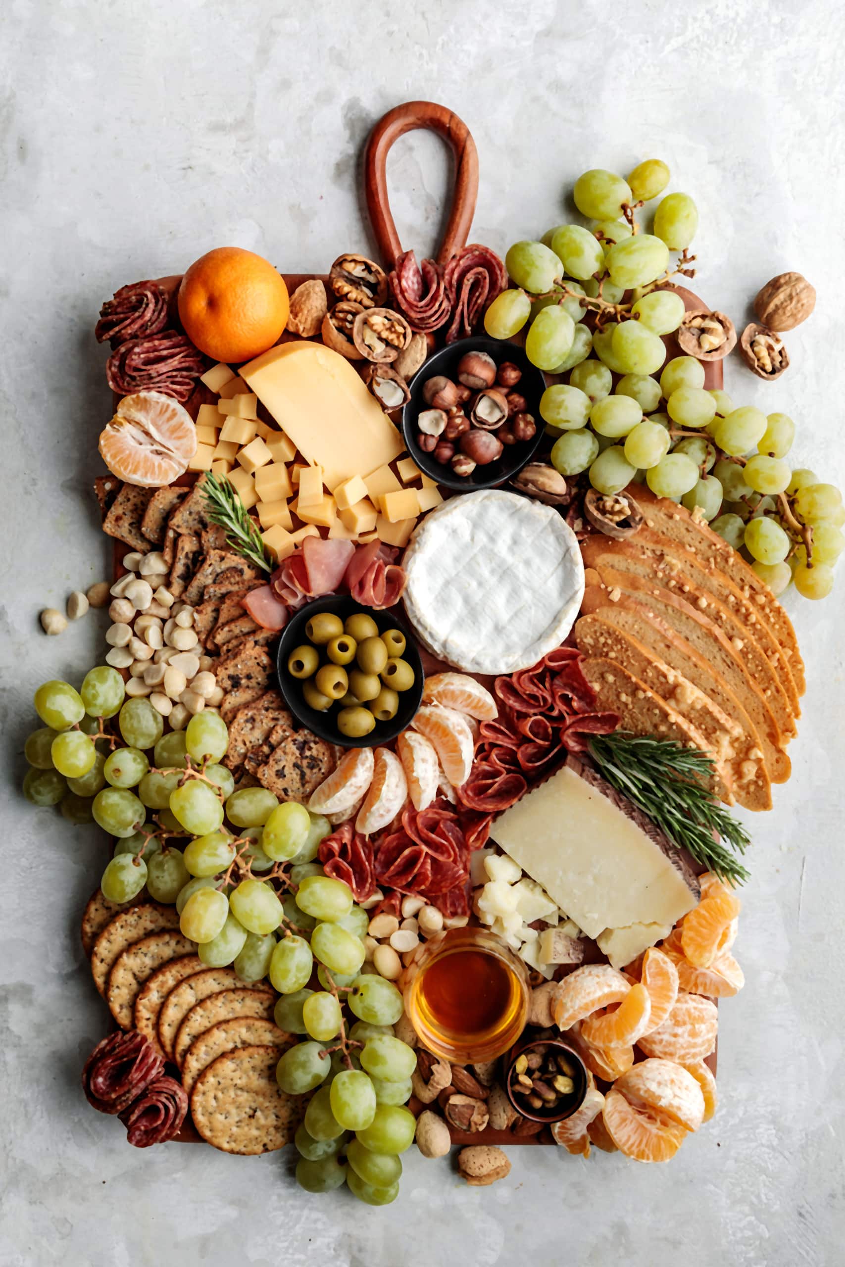 How to build an easy and impressive Winter Cheese Board featuring seasonal fruits, nuts, olives and a variety of cheese and charcuterie.