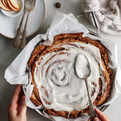 Apple cinnamon roll cake on skillet with icing