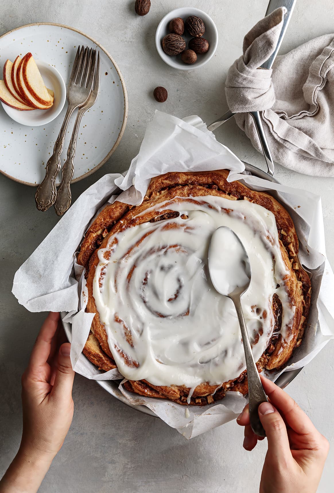 Apple cinnamon roll cake on skillet with icing