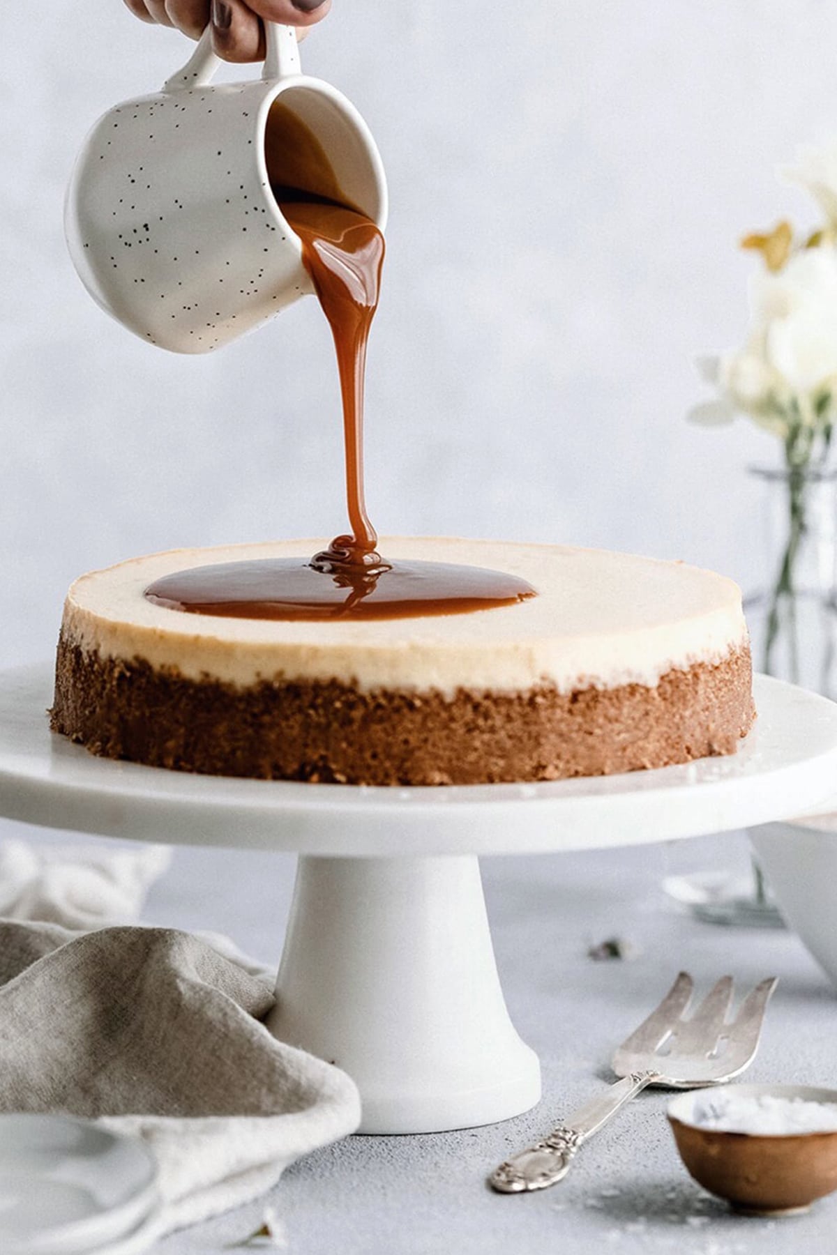 Caramel cheesecake with graham cracker crust and homemade caramel sauce poured on top.