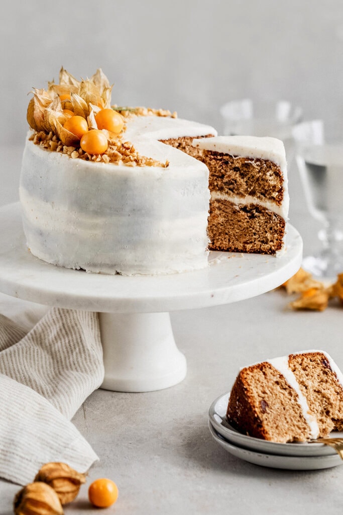 Holiday Fruit Cake (Torta Negra) with brown butter frosting slice on cake stand