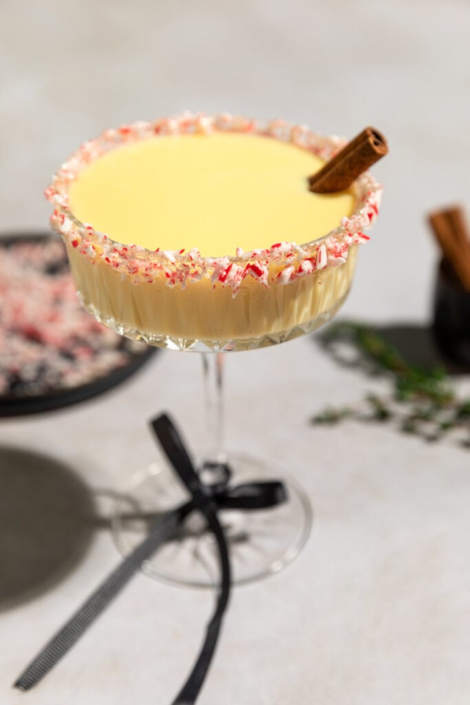Ponche Crema (Venezuelan Eggnog) is a traditional holiday drink served in a glass with peppermint candy rim.