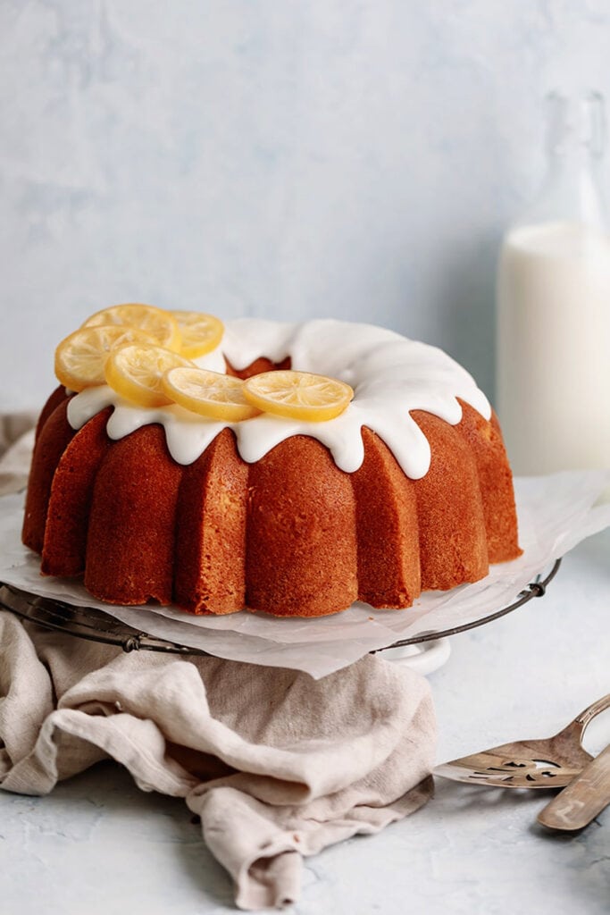 lemon bundt cake with lemon icing and decorated with dried lemons, on cake pan