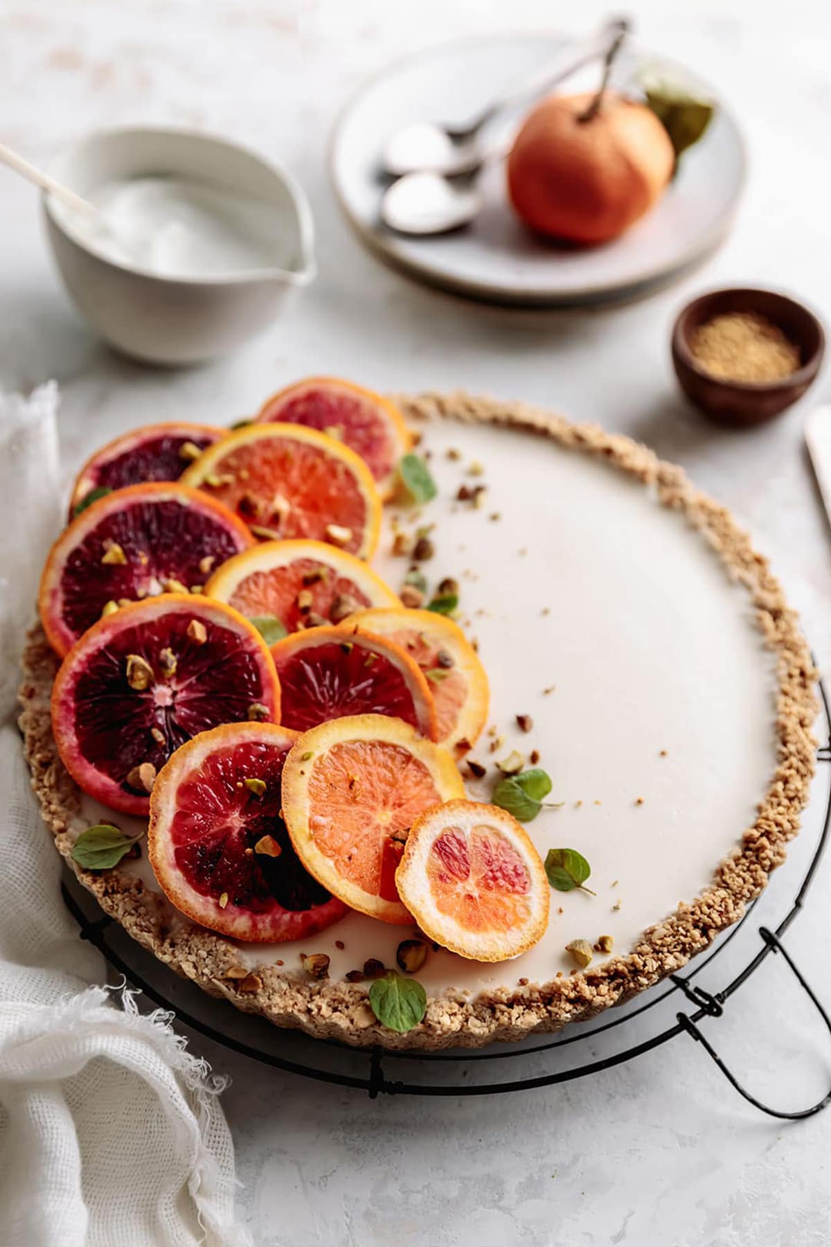 Easy No-Bake Greek Yogurt Tart topped with fresh blood oranges comes together in minutes. It's made with a gluten-free crust with oats, almonds and honey. Perfect for brunch or dessert on a spring/summer day.